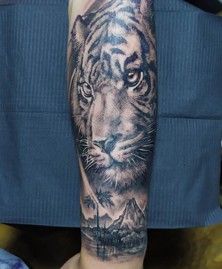 Tiger Realistic tiger portrait tattoo over a beautiful island scenery in the distance. Tattoo by VampyCrafts in Cologne
