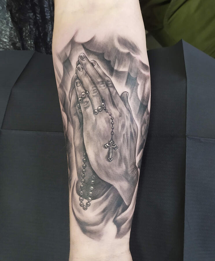 Realistic religious tattoo of praying hands.