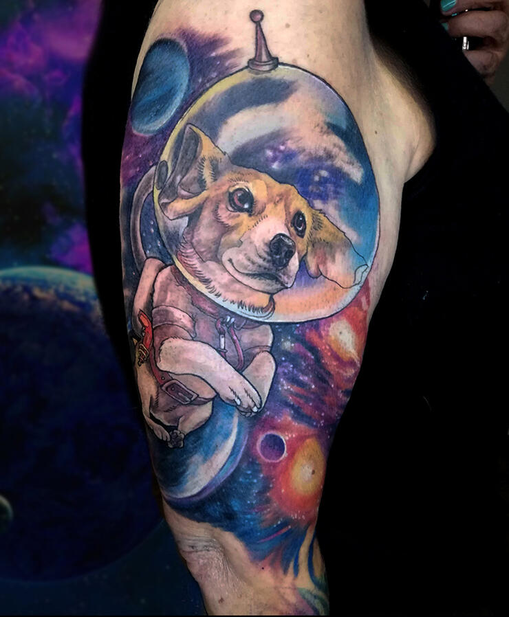 Cosmic tattoo design with planets and a dog in a space suit. Full colour neo-traditional style.